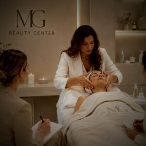 Formatrice de MG Beauty Center montrant un soin du visage à des stagiaires qui prennent des notes